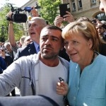 A migrant takes a selfie with German Chancellor Merkel outside a refugee camp near the Federal Office for Migration and Refugees after registration at Berlin's Spandau district